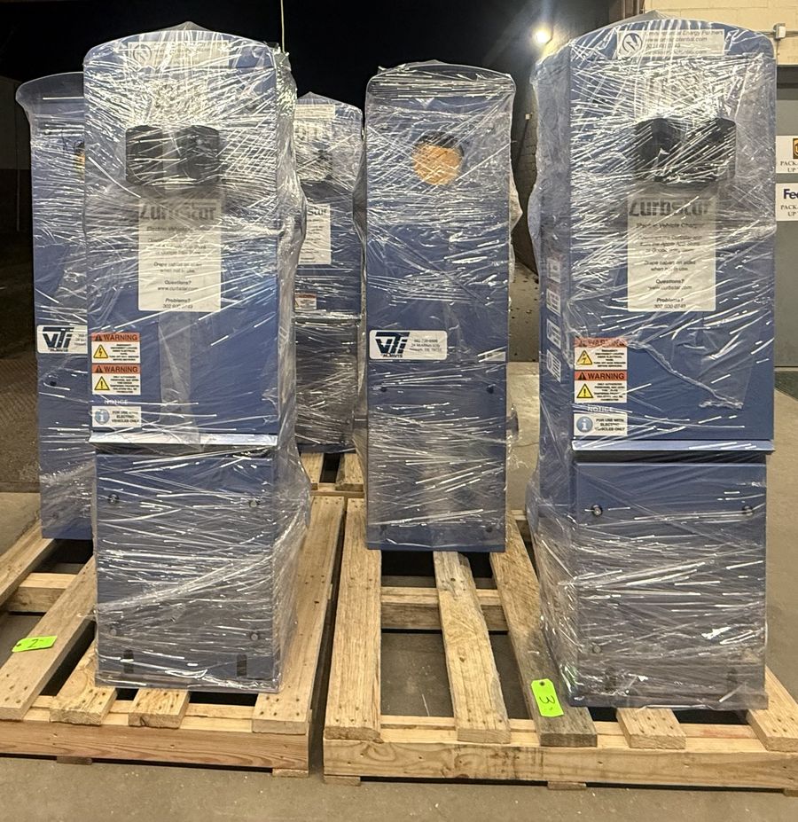 Five shrink-wrapped Curbstar pedestals on pallets at a loading dock